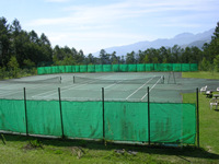 2面あるテニスコートの写真。周りはネットで囲まれている。