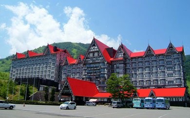 三角型で赤色をした屋根と、外装に細かい装飾が施されている大きな建物の写真