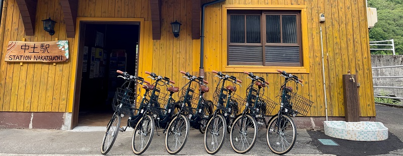 6台の自転車が建物の前に並び、建物には「中土駅」の看板がある写真