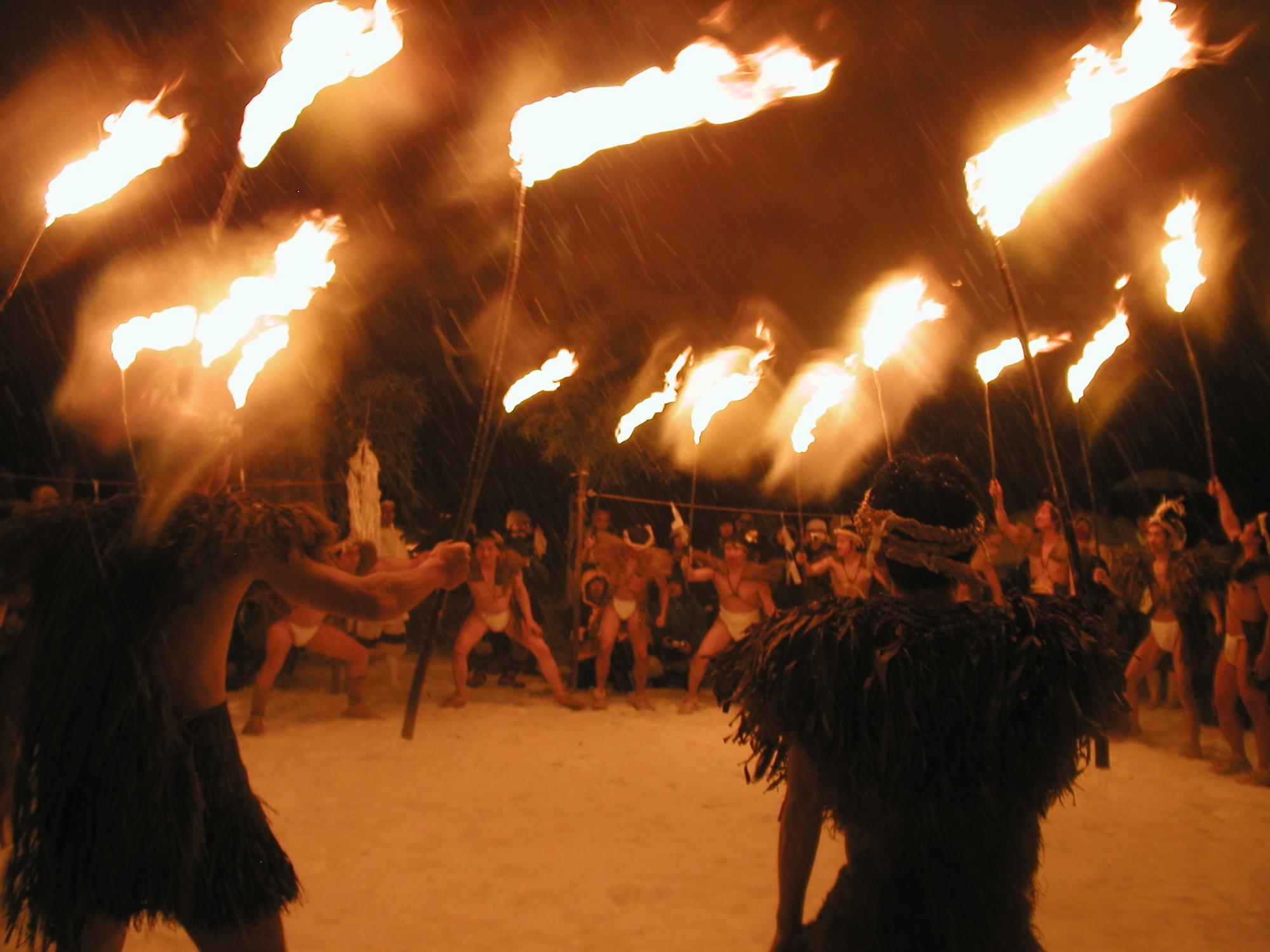 伝統行事でふんどし姿で火がついた棒を持っている男性たちの写真