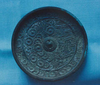 古鏡菊散檜垣双雀鏡の写真。円形の古鏡。