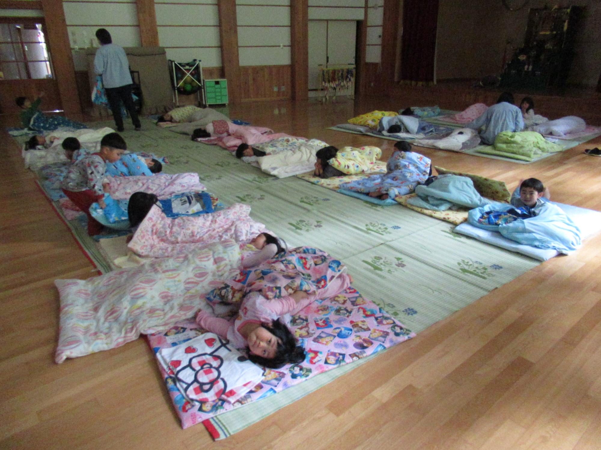 並べられた布団で寝る児童達の写真