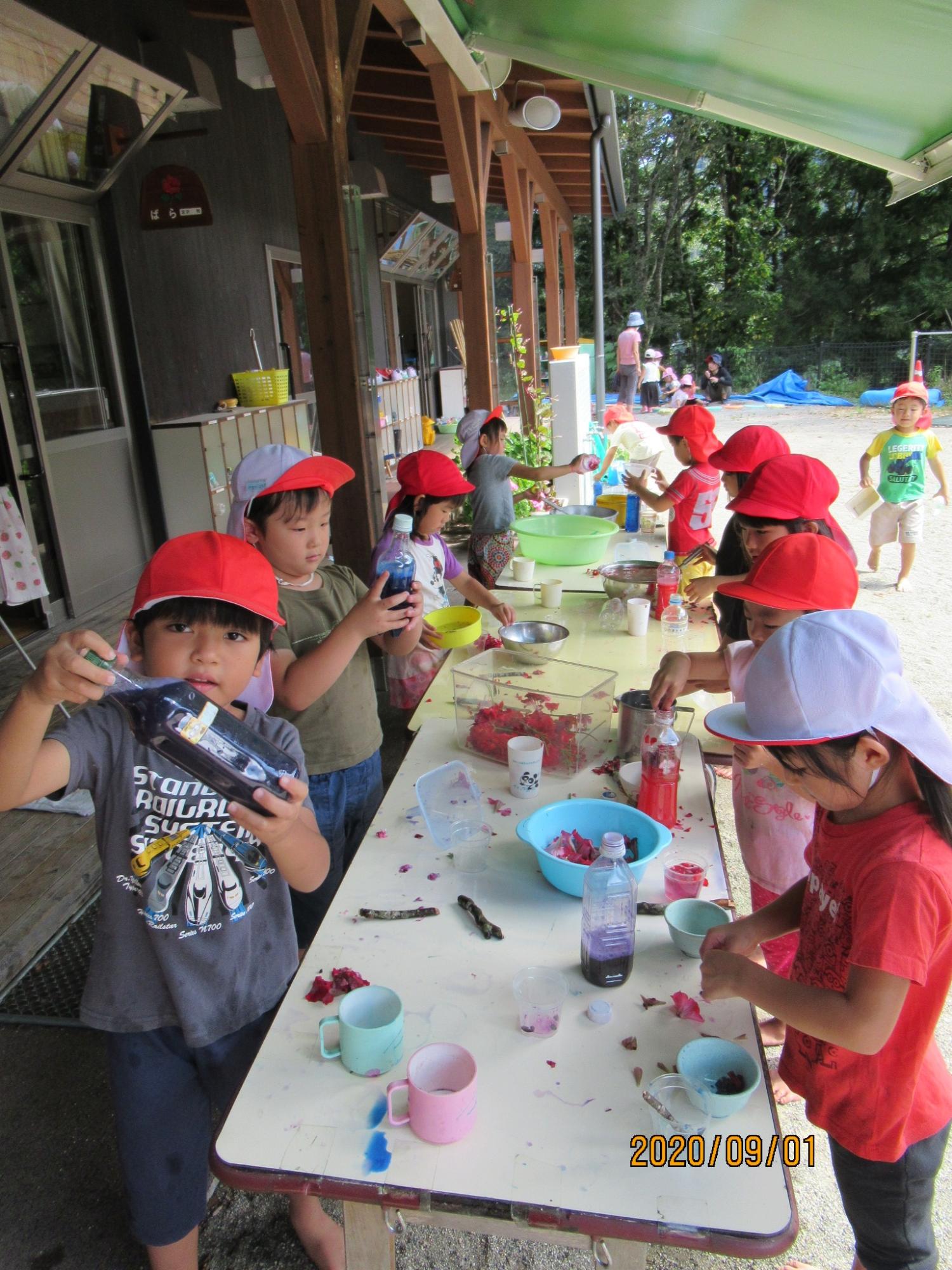 筆や刷毛で看板を作っている園児たちの写真