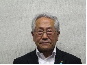 黒のスーツを着て眼鏡をかけている白髪の男性の写真