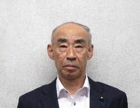 胸元にバッジを付けた男性の写真