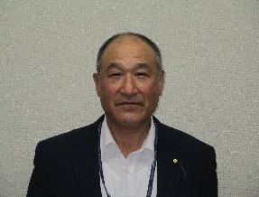 黒のスーツを着た男性が微笑んでいる写真