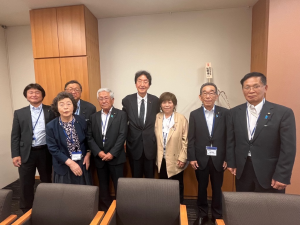 スーツの男女8人が並んでいる写真