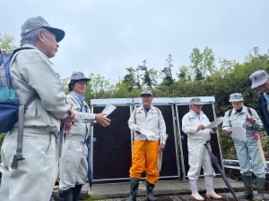 集まって話しあっている作業着姿の人達の写真