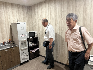 部屋の台所を見る男性2人の写真