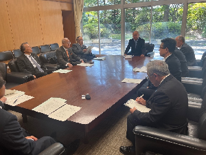 資料を出しながら机を囲んで話すスーツの男性達の写真