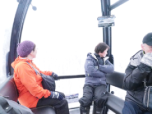 ゴンドラ内に座って外を見る人たちの写真