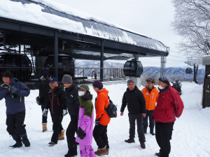 ゴンドラ乗り場付近の雪道を歩く人達の写真